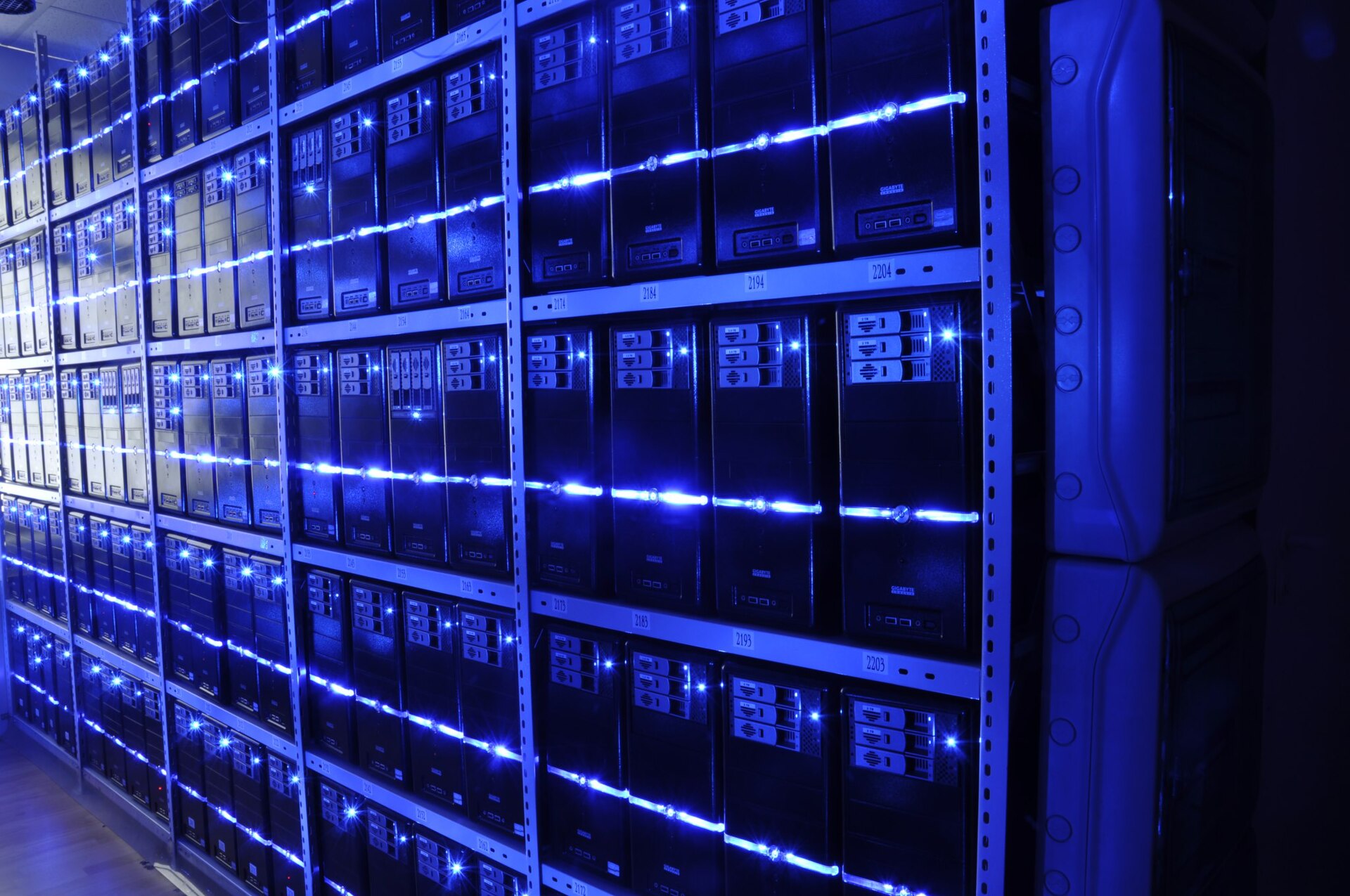 A brightly lit aisle of server racks in a data center